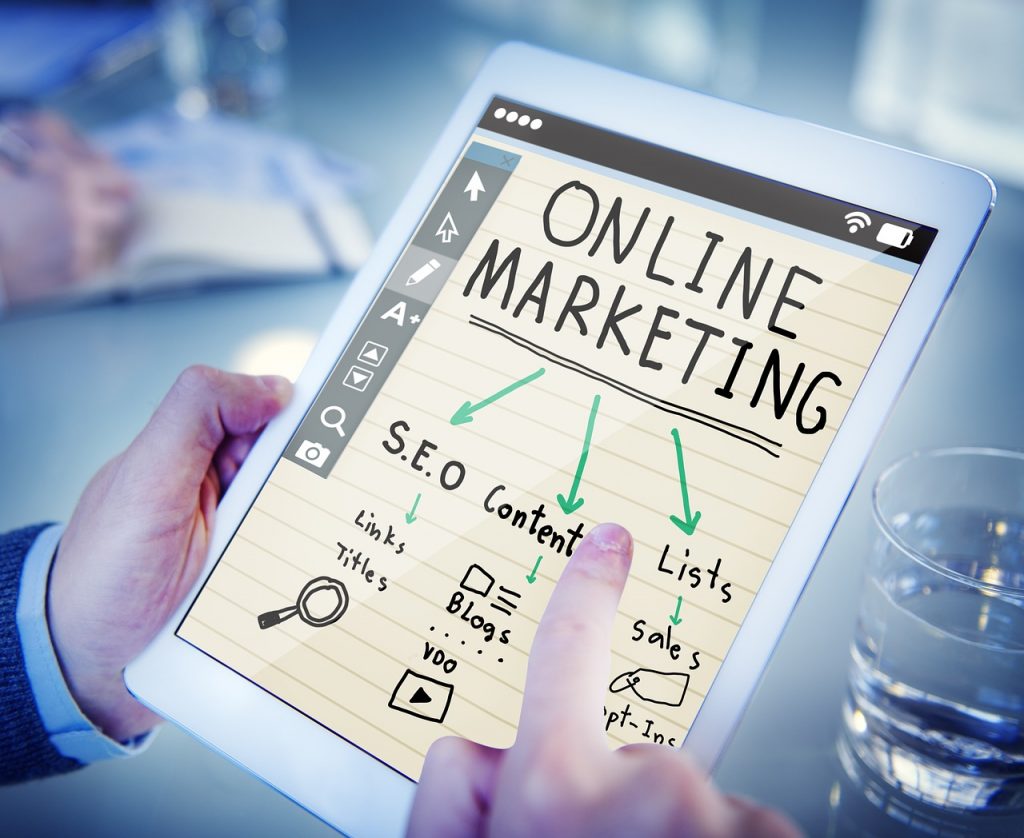 Tablet in Händen zeigt Skizze mit dem Begriff „Online Marketing“ und dazugehörigen Elementen wie SEO, Content, Blogs und Sales – Sinnbild für digitale Marketingstrategien.