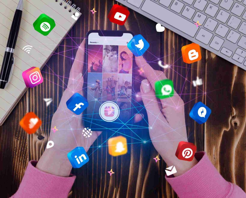 Smartphone in der Hand über einem Schreibtisch mit animierten Social-Media-Icons wie Instagram, Facebook, LinkedIn und YouTube – symbolisiert vernetzte Kommunikation, Social Media Marketing und digitale Markenführung bei Events wie PRC15 in Düsseldorf.