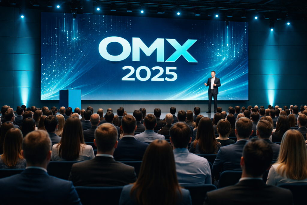 Blick auf eine moderne Marketing-Konferenz mit großem Publikum, digitaler Bühne und Präsentation auf LED-Screen im Rahmen der OMX 2025.